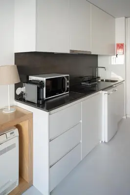 a kitchen with white cabinets and a microwave on a counter at I Loft Porto in Porto