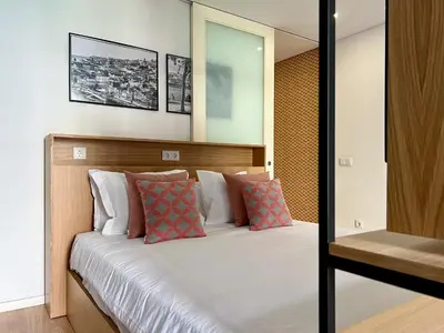 a bedroom with a large bed with pillows at Light-Filled Apartment with Garden • Downtown in Porto