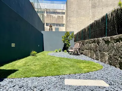 a garden with a bench and a stone wall at Light-Filled Apartment with Garden • Downtown in Porto