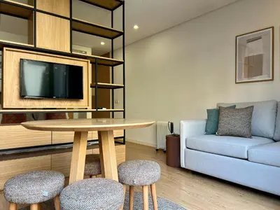 a living room with a table and a couch at Light-Filled Apartment with Garden • Downtown in Porto