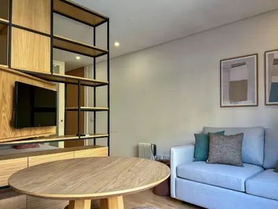 a living room with a table and a couch at Light-Filled Apartment with Garden • Downtown in Porto