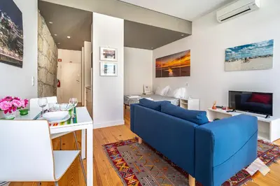 a living room with a blue couch and a table at Bright Apartment • Downtown Porto in Porto