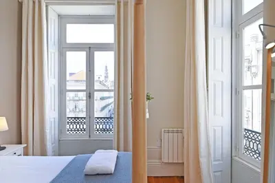 a bedroom with a bed and a large window at Inn Oporto Old Town Apartments in Porto