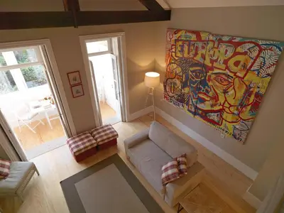 a living room with a couch and a painting on the wall at Oporto Medusa Apartment in Porto