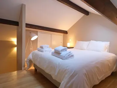 a bedroom with a large white bed with towels on it at Oporto Medusa Apartment in Porto