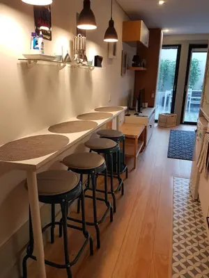 a kitchen with a long bar with stools at Porto Belo Clérigos in Porto