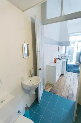 a bathroom with a white sink and a blue tile floor at Casa do Poeta & Guitarra by PCH in Porto