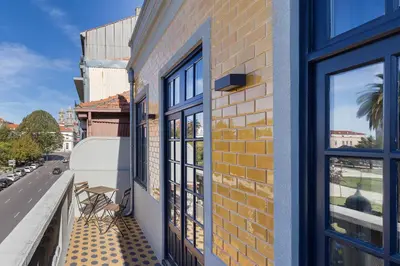 a balcony with chairs and windows on a building at Casa Amarela in Porto