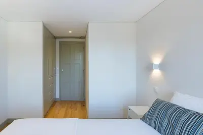 a bedroom with a white bed and a hallway at Casa Amarela in Porto