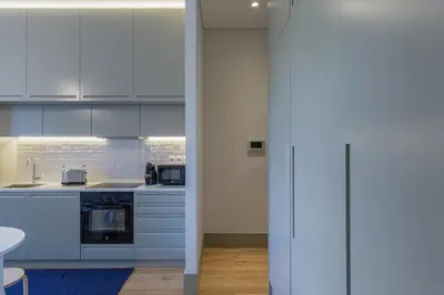 a kitchen with white cabinets and a stove top oven at Casa Amarela in Porto