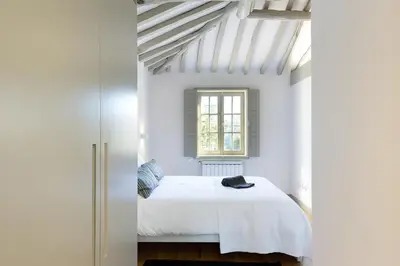a bedroom with a white bed and a window at Casa Amarela in Porto