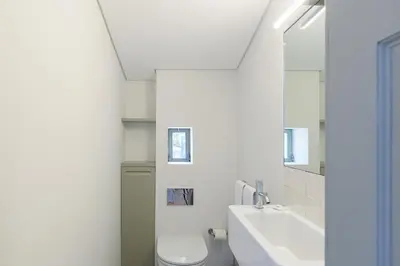 a white bathroom with a toilet and a sink at Casa Amarela in Porto