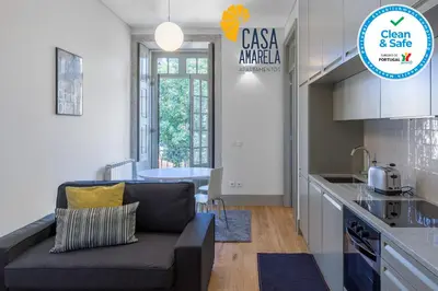 a living room with a couch and a kitchen at Casa Amarela in Porto