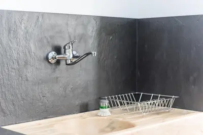 a bathroom sink with a faucet on a wall at GuestReady - Warm cocoa retreat in Cedofeita in Porto