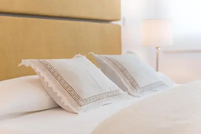 two white pillows sitting on a white bed at GuestReady - Warm cocoa retreat in Cedofeita in Porto