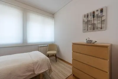 a bedroom with a bed and a dresser and a chair at GuestReady - Warm cocoa retreat in Cedofeita in Porto