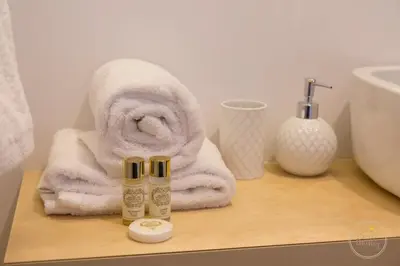 a bathroom with a towel and a bottle of lotion at Hello Porto Ceuta Residences in Porto
