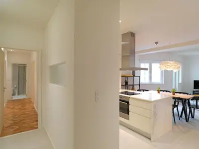 a white kitchen with a table and a counter top at FLH Porto Central Apartment in Porto