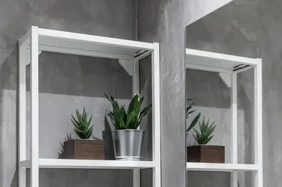 two white shelves with potted plants on them at Casa do Ofício - Caldeireiro in Porto