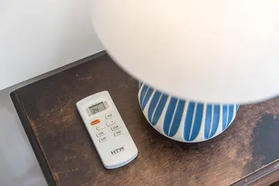 a remote control sitting on a table next to a vase at Casa do Ofício - Caldeireiro in Porto