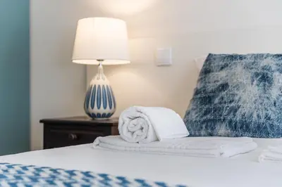a bed with towels and a lamp on a table at Casa do Ofício - Caldeireiro in Porto