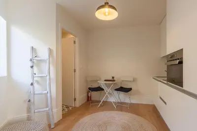 a small kitchen with a table and chairs in a room at Secret Camões in Porto