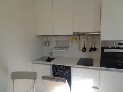 a white kitchen with a sink and a stove at Secret Camões in Porto