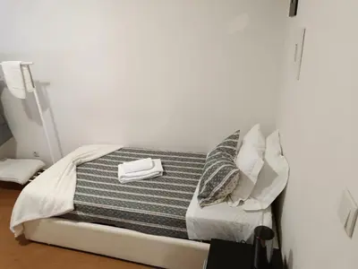 a bed with a striped blanket and pillows on it at Portus Ribeira House in Vila Nova de Gaia