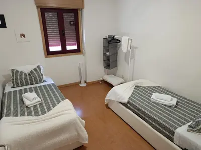 a bedroom with two beds and a window at Portus Ribeira House in Vila Nova de Gaia
