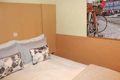 a bedroom with a bed with a bike on the wall at Residencial Paranhos in Porto
