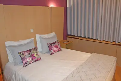 a bedroom with a bed with two pillows on it at Residencial Paranhos in Porto