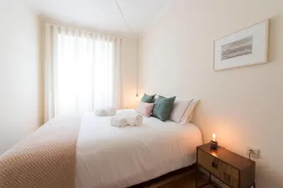 a bedroom with a white bed with towels on it at Tripas-Coração, Breiner GreenHouse in Porto