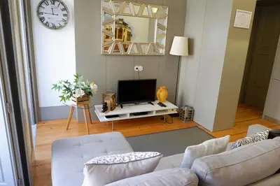 a living room with a couch and a tv at Porto Urban Art Trindade in Porto