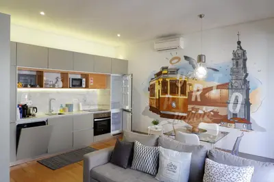a living room with a couch and a kitchen with a train mural at Porto Urban Art Trindade in Porto