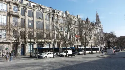 a large building with buses parked in front of it at Porto Urban Art Trindade in Porto