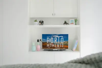 a shelf with a tv and a movie on it at Porto Moments Apartments by Portugal Collection in Vila Nova de Gaia