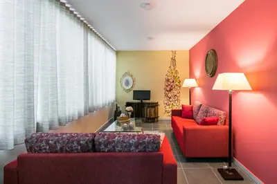 a living room with red furniture and a red wall at Camarinha Oporto Apartments in Porto