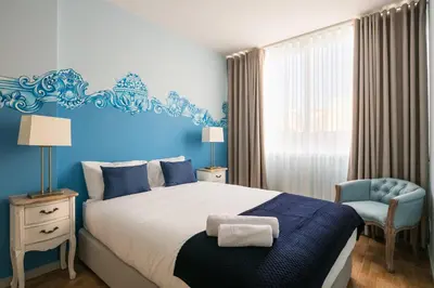 a bedroom with a large bed and a blue wall at Camarinha Oporto Apartments in Porto