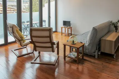 a living room with a bed and chairs and a table at Bonjardim Flats - T2 com Varanda in Porto