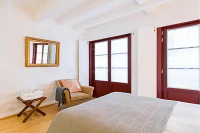 a bedroom with a bed and a chair and a mirror at Porto Emotions - Caldeireiros in Porto