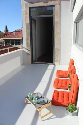 an orange couch and a table on a balcony at Bonjardim Flats - T1 + 1 com terraço in Porto