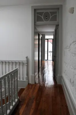 a hallway with wooden floors and a staircase in a house at Bonjardim Flats - T1 + 1 com terraço in Porto