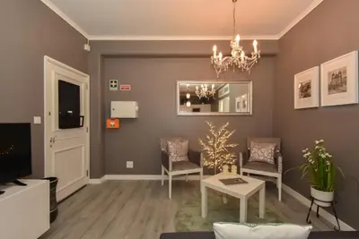 a living room with a tv and a chandelier at Oporto Batalha Residence free parking in Porto