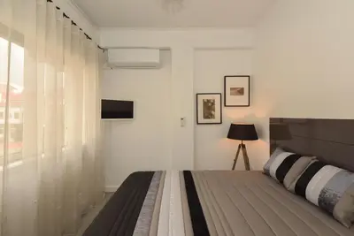 a white bedroom with a bed and a window at Oporto Batalha Residence free parking in Porto