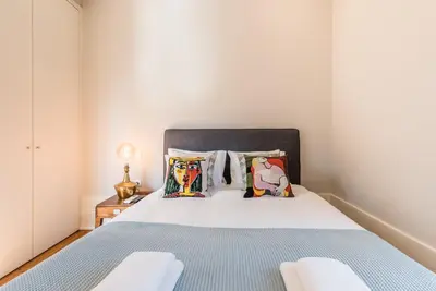 a bedroom with a large bed with blue sheets and pillows at GuestReady - Chic retreat in the heart of Porto in Porto