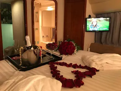 a hotel room with a bed with red roses on it at Porto Private Yacht- Accommodation Douro River in Porto