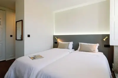 a large white bed with two pillows in a room at Cosme Apartments by Olala Homes in Porto