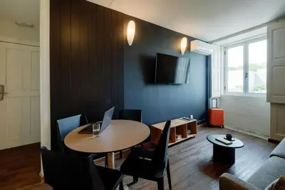 a living room with a table with a laptop on it at Cosme Apartments by Olala Homes in Porto