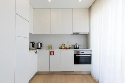 a kitchen with white cabinets and a stove at Oporto up Town in Porto
