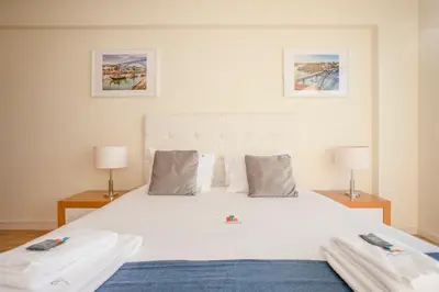 a bedroom with a large white bed with two lamps at Liiiving in Porto | Downtown View Apartment in Porto